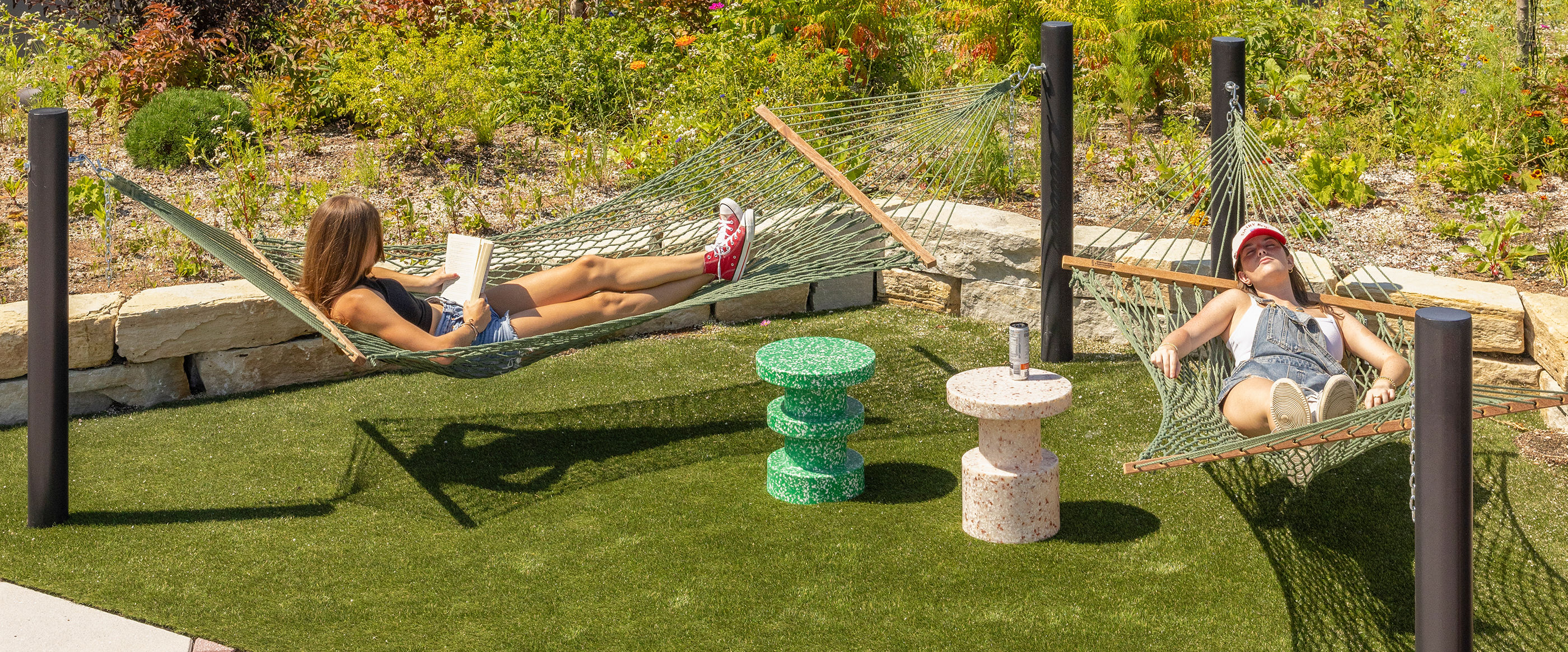 Two friends using hammocks outside